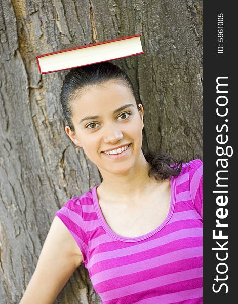 young woman holding book on her head. young woman holding book on her head