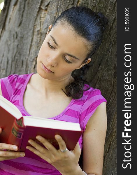 Young woman reading book outdoor. Young woman reading book outdoor