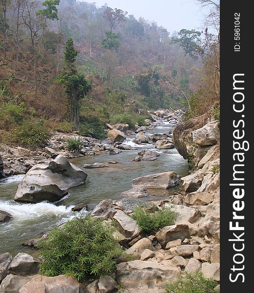 Beautiful mountain stream flowing among rugged, rocky mountains in central Thailand. Beautiful mountain stream flowing among rugged, rocky mountains in central Thailand.