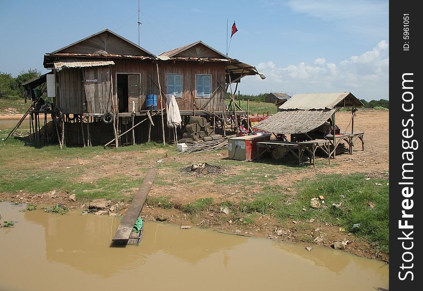 Stilt house on the banks of a muddy dry season river in central Cambodia. he river flows into Lake Tonle (Sap), which is a very large lake. Stilt house on the banks of a muddy dry season river in central Cambodia. he river flows into Lake Tonle (Sap), which is a very large lake.