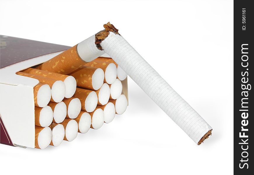 The broken cigarette and pack of cigarettes on a white background