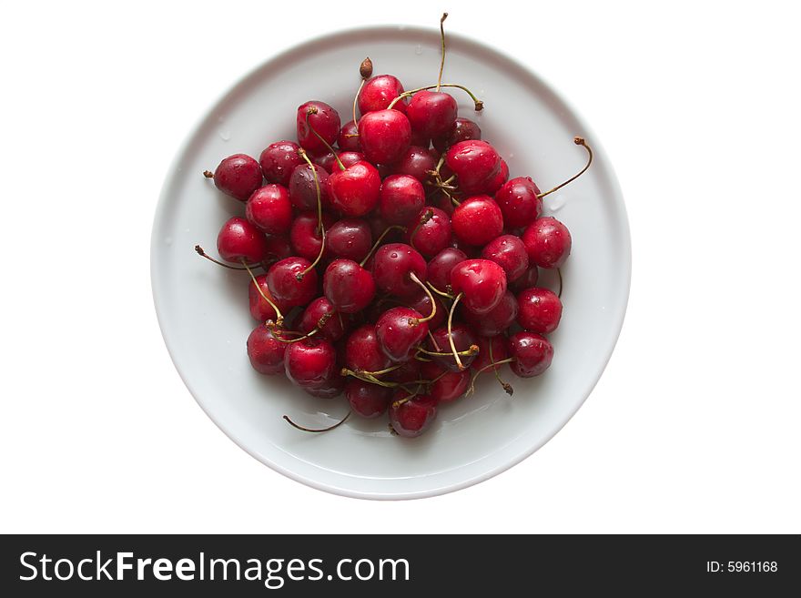 Sweet cherries on porcelain plate isolated on white