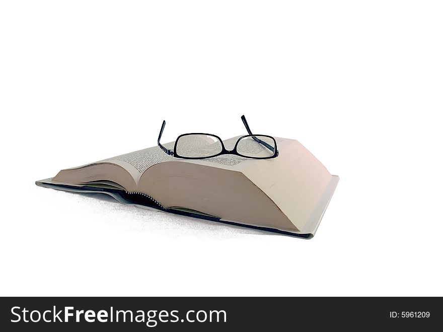 Large book with reading glasses on top. Large book with reading glasses on top