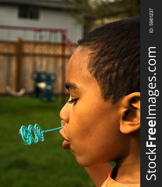 5 year old African American boy blowing bubbles in the afternoon sun. 5 year old African American boy blowing bubbles in the afternoon sun.