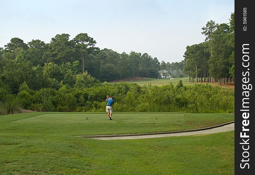 A golfer tees off on this beautiful Myrtle Beach, south Carolina golf course. A golfer tees off on this beautiful Myrtle Beach, south Carolina golf course.