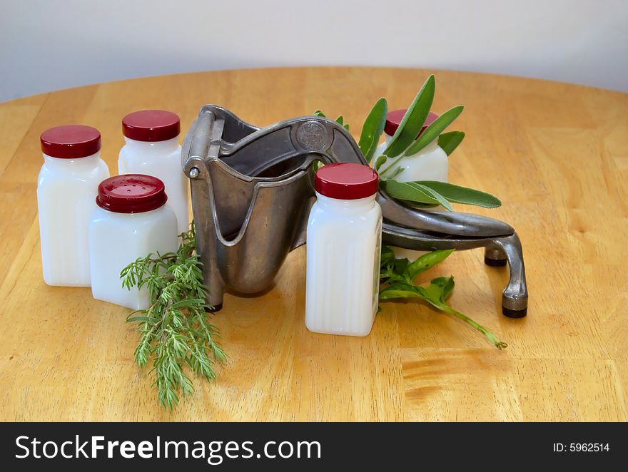 An antique juicer with spice jars and herbs. An antique juicer with spice jars and herbs