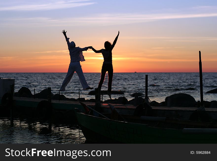 Silhouette of the girl on a decline at the sea