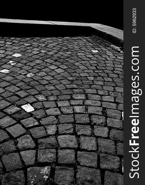 High contrast grayscale picture of an old stone pavement and a stone curb. High contrast grayscale picture of an old stone pavement and a stone curb