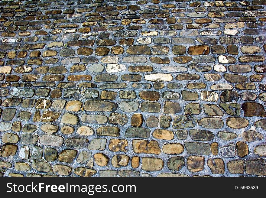 Old pavement made of colourful stones of different shapes and sizes