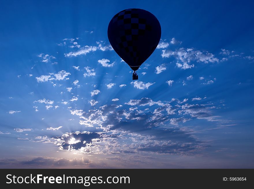 A hot air balloon is silhouetted at sunset. A hot air balloon is silhouetted at sunset.