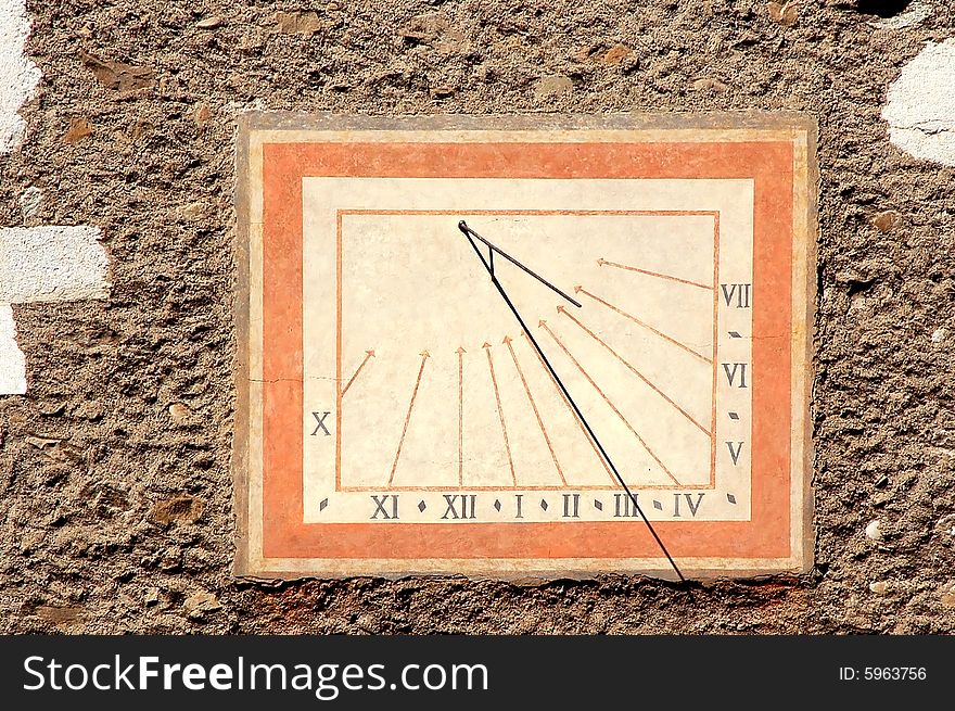 Medieval sundial with roman numerals on an old stone wall. Medieval sundial with roman numerals on an old stone wall