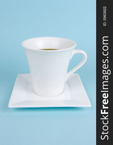 A cup of black coffee isolated against a blue background