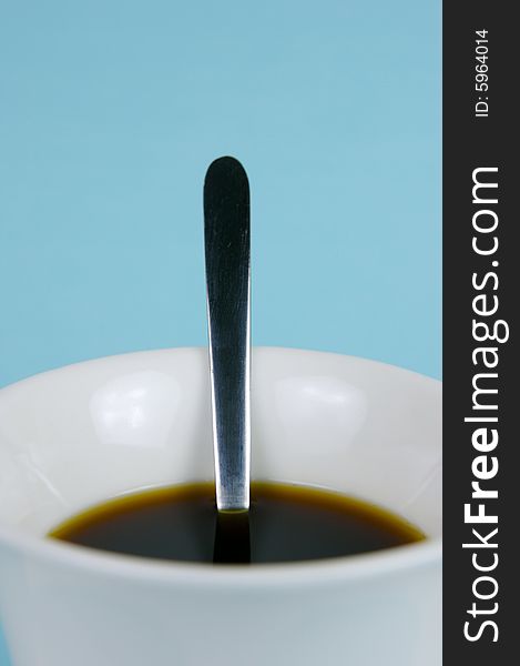 A cup of black coffee isolated against a blue background