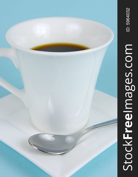 A cup of black coffee isolated against a blue background