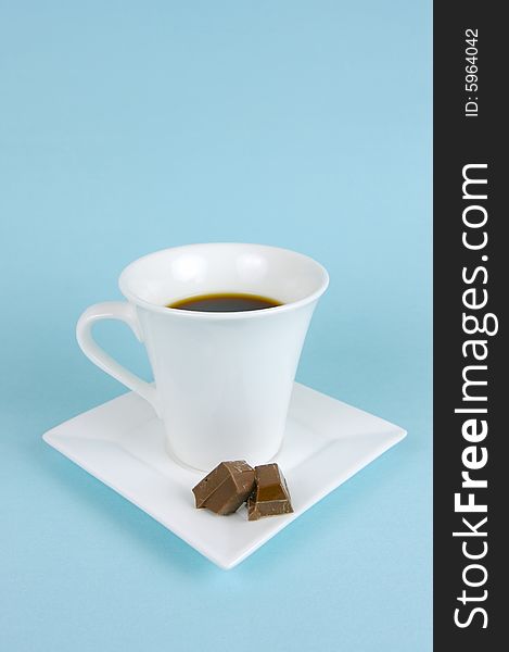 A cup of black coffee isolated against a blue background