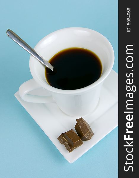 A cup of black coffee isolated against a blue background