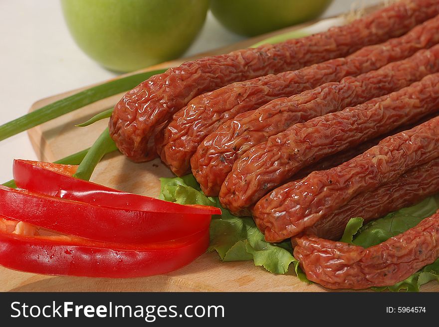 Few tiny fat sausages with fresh vegetables