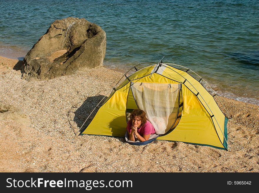 Woman lying in tent at sand sea beach and lookin up. Woman lying in tent at sand sea beach and lookin up