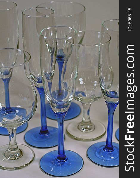 Several clean and shiny wine glasses with blue stems isolated and ready for a party!. Several clean and shiny wine glasses with blue stems isolated and ready for a party!