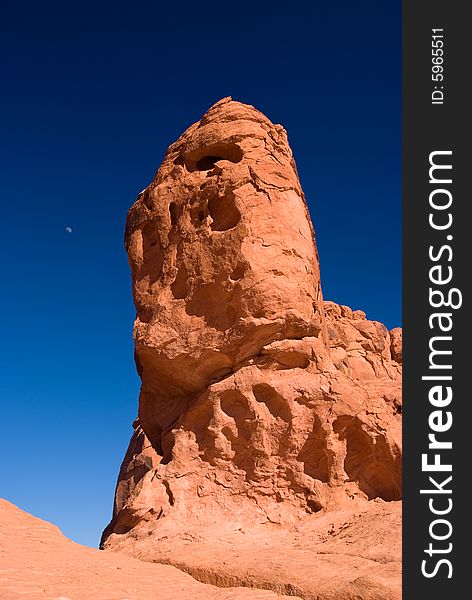 Red Rock With Moon Under Blue Sky