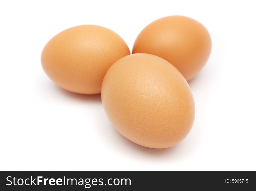 Close up of three eggs on white background.