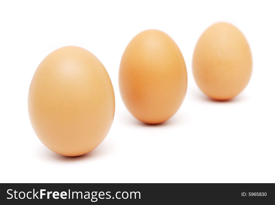Close up of three eggs standing on white background. Close up of three eggs standing on white background.