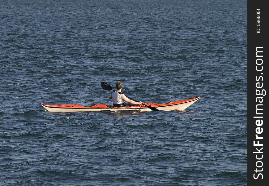 Paddler in a boat paddling across a lake