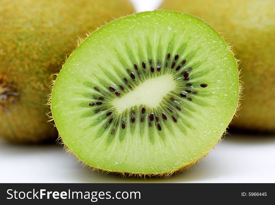 Close up of half kiwi fruit with two at the back. Close up of half kiwi fruit with two at the back.