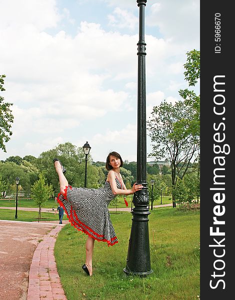 The beautiful girl poses at a lamppost. The beautiful girl poses at a lamppost