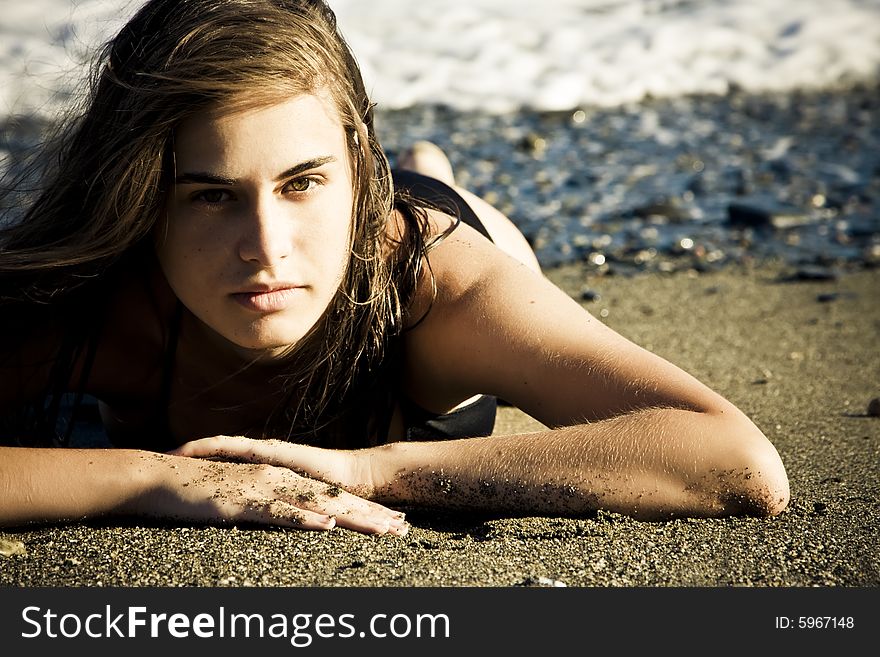 Green eyed beauty laying over the sand. Green eyed beauty laying over the sand