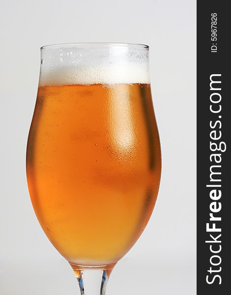A glass of icecold beer, with condensing water on the glass.