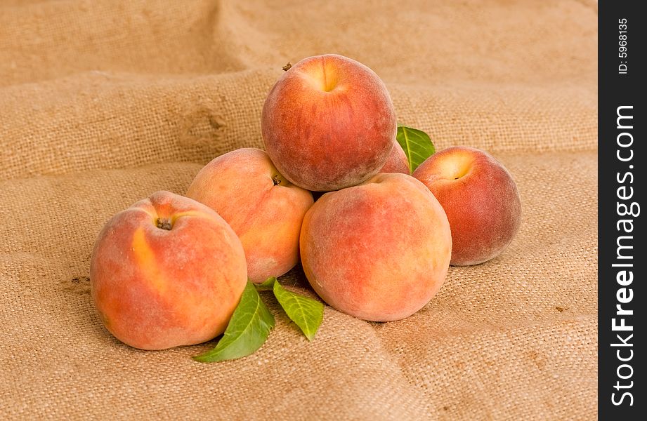 Ripe peaches on burlap texture