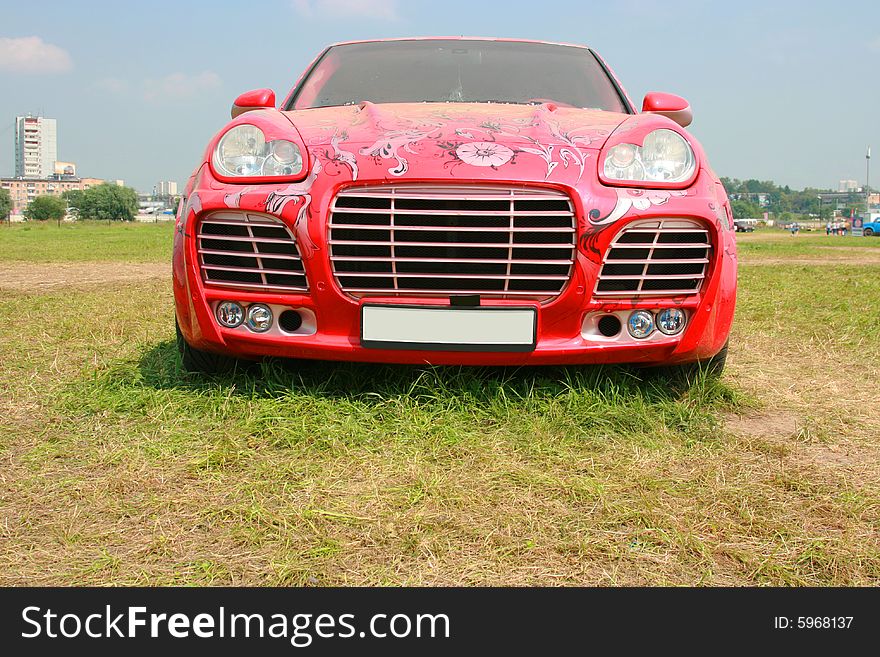 The luxury car of red color at an exhibition