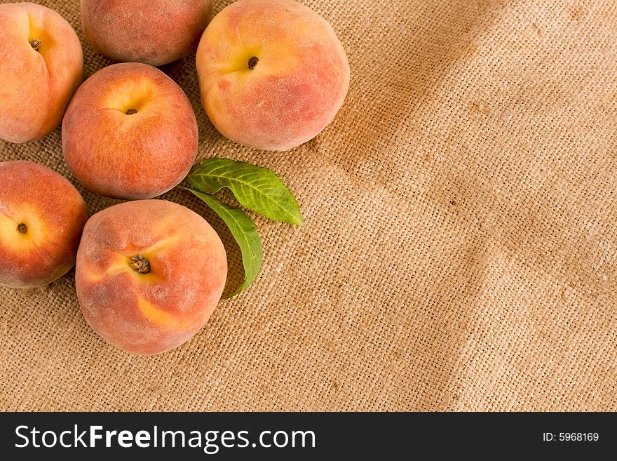 Ripe peaches on burlap texture