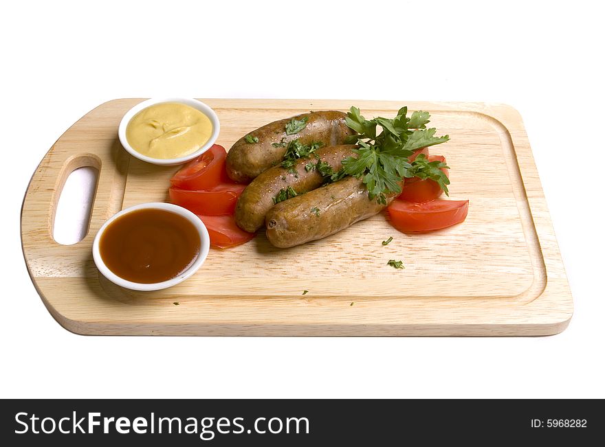 Three frankfurters with tomatoes, herbs and two kinds of sauces - mustard and ketchup on wooden board