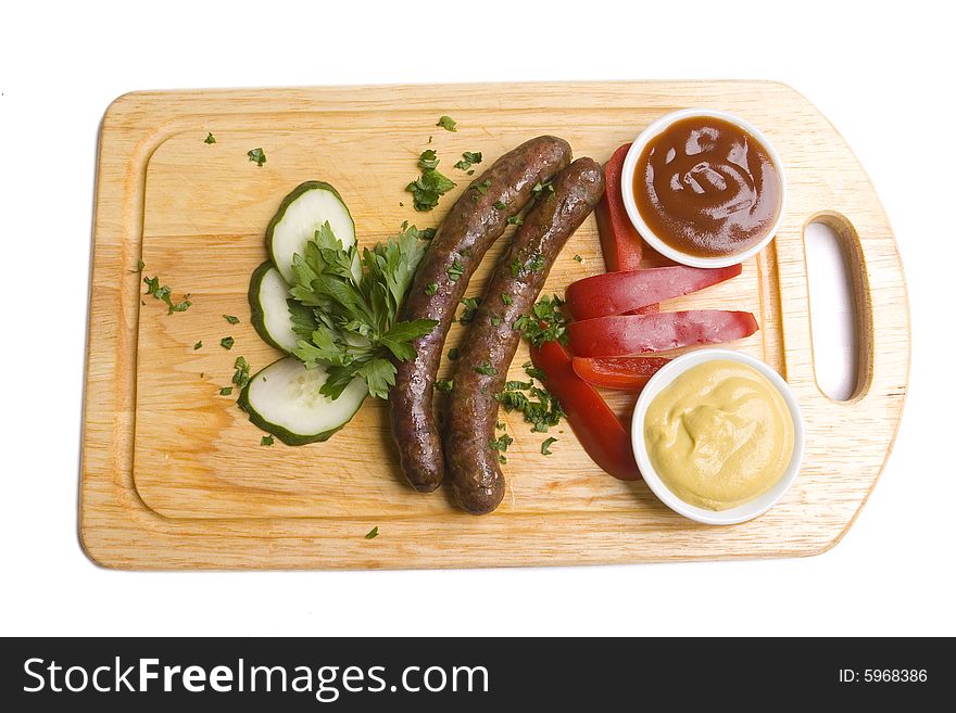 Two long frankfurters with pepper, cucumber, herbs and two kinds of sauces - mustard and ketchup on wooden board