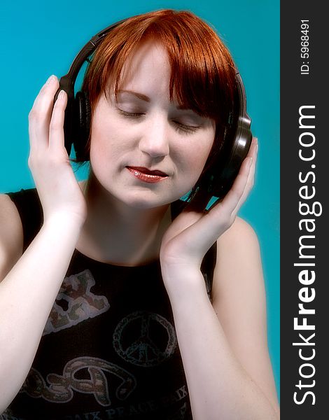 Red haired girl listening to her favourite music. Red haired girl listening to her favourite music