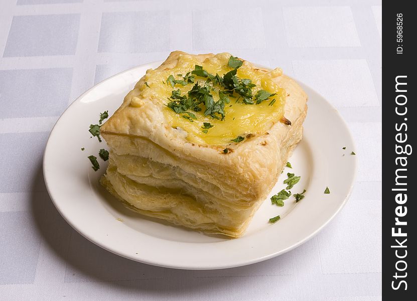 Pie with cheese on white plate