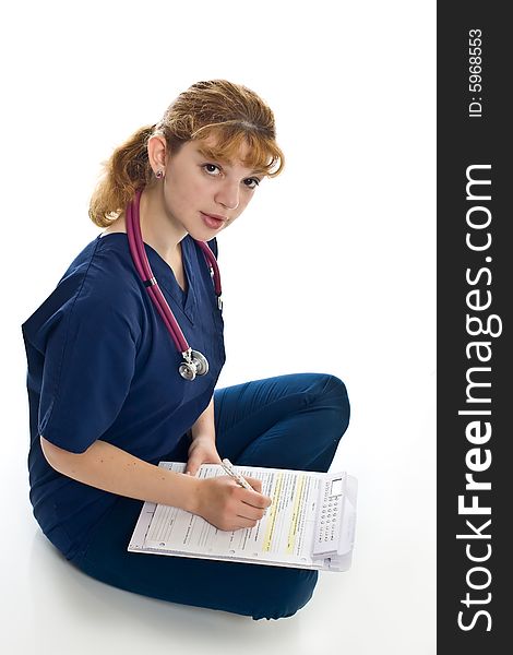 Young female doctor with stethoscope and writing pad over white background