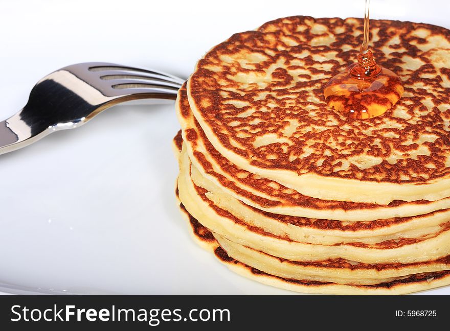 Pile of american pancakes with syrup poured on them. Pile of american pancakes with syrup poured on them