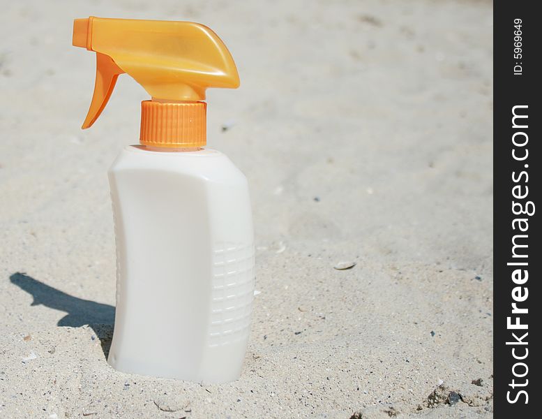Protective cream in sand on a beach