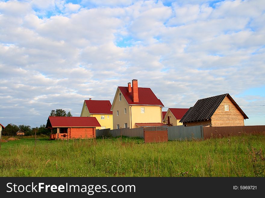 House in a countryside on the big green lawn under the sky with clouds. House in a countryside on the big green lawn under the sky with clouds