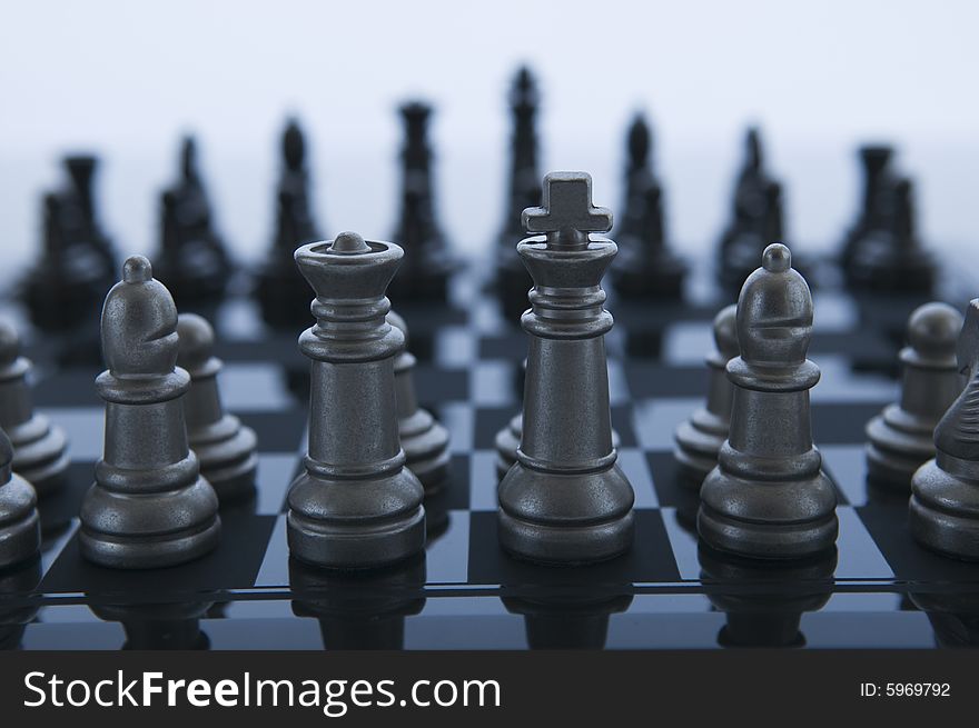 Metal Chess pieces facing eachother with white background. Metal Chess pieces facing eachother with white background