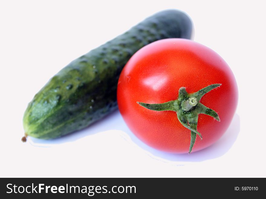 A fresh tomato and cucmber isolated on white background. A fresh tomato and cucmber isolated on white background
