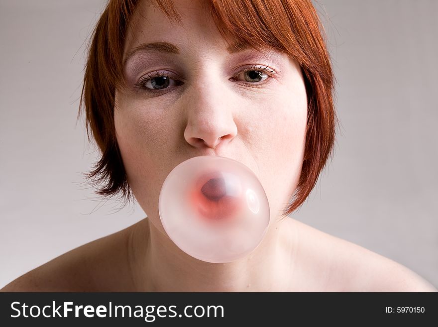 Red haired girl is eating fresh bubblegum. Red haired girl is eating fresh bubblegum