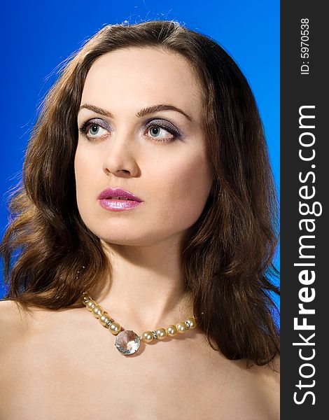 Beautiful woman with jewelry on blue