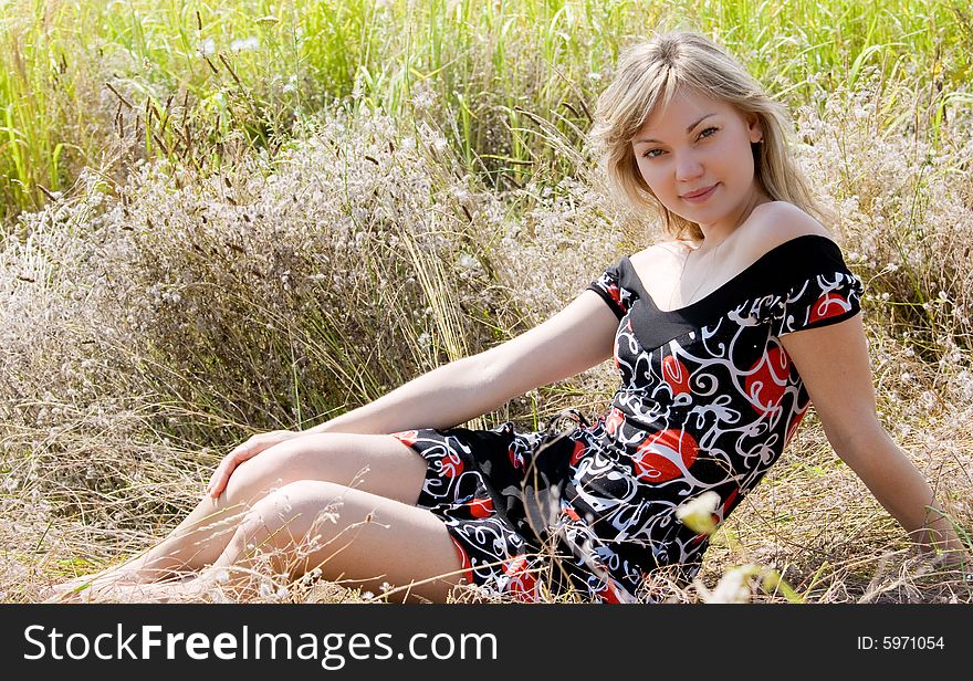 Beautiful young girl on summer meadow background