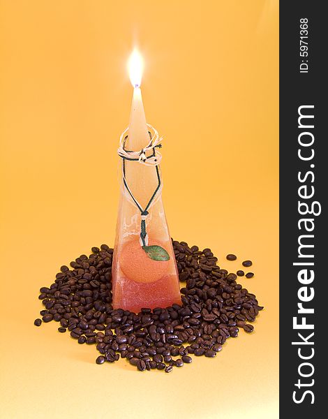 Orange candle with coffee beans