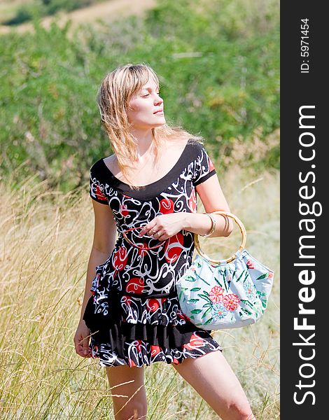 Beautiful Young Lady With Handbag On Green Meadow