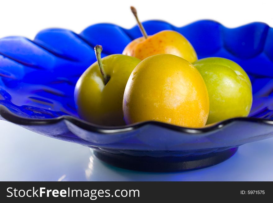 Group of plums on blue glass plate. Group of plums on blue glass plate